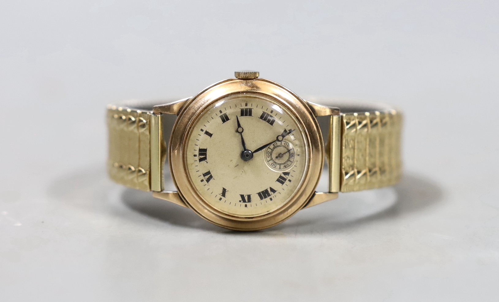 A gentleman's mid 20th century 9ct gold manual wind wrist watch, with Roman dial and subsidiary seconds, on associated flexible strap, cased diameter 29mm.